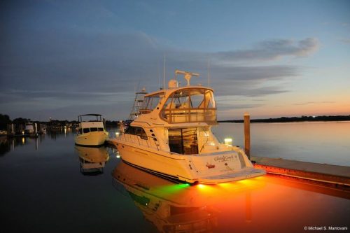 Fishing boat moored in harbour at sunrise showing orange LED