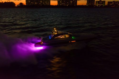 The speedboat using the pink LED light while travelling along the dark sea