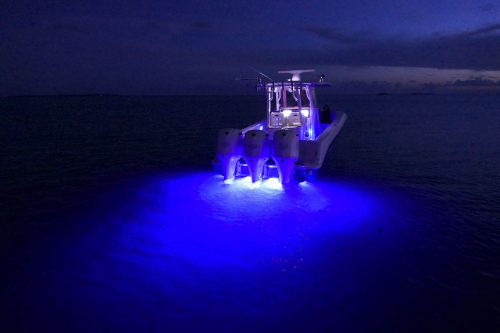 A boat travelling at night using the dark blue led light
